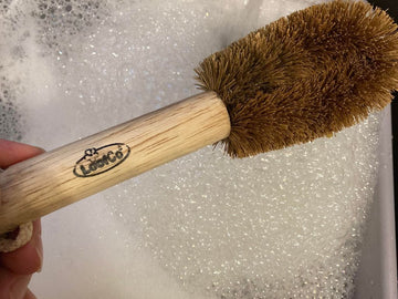 loofco washing up brush held over sink of bubbly water