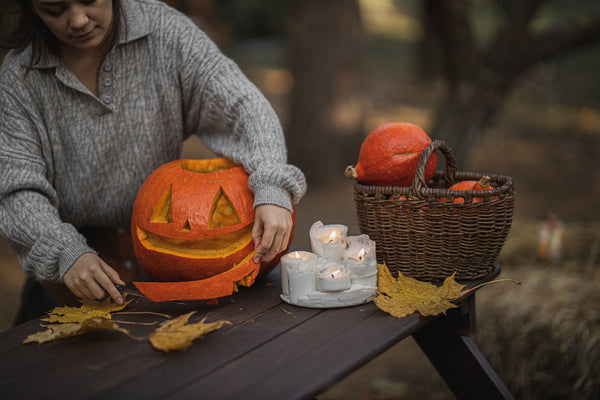 Woman carves Halloween pumpkin