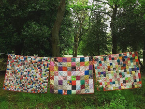 Kate, with the first patchwork quilt she ever made, behind her.